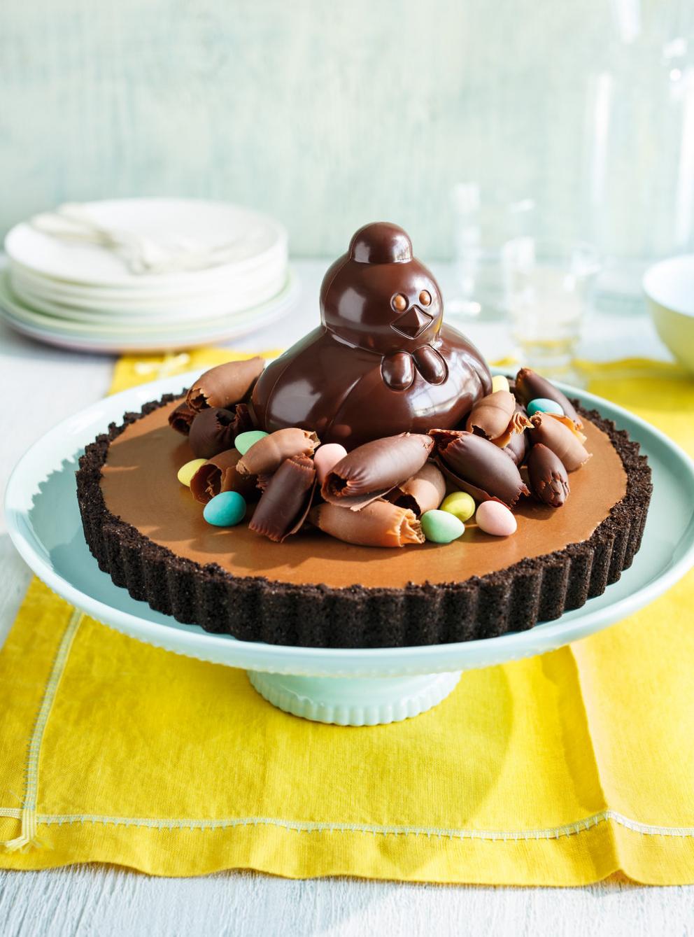 Chocolate hen on a pie with chocolate shavings and candy eggs